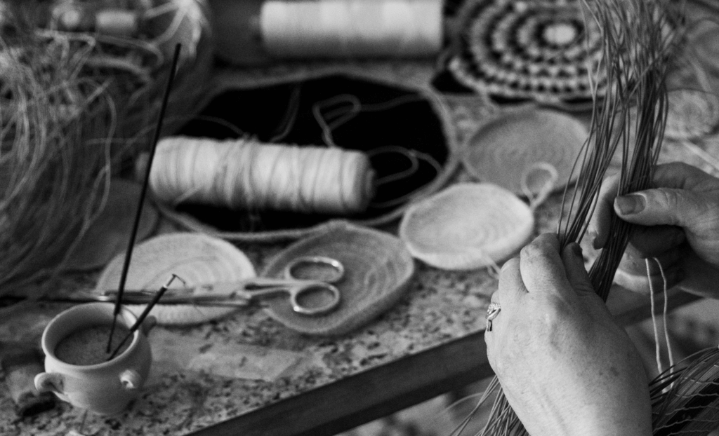 Femme en train de tresser un plateau en alfa
